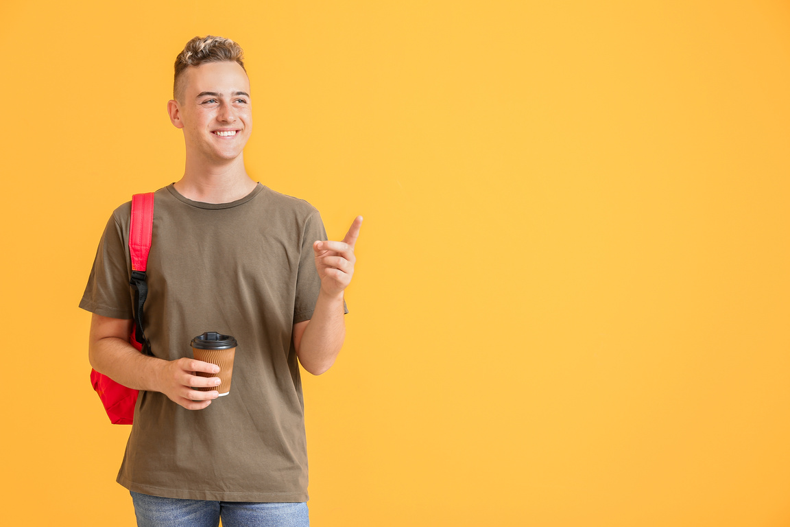 Male Student Showing Something on Yellow Background